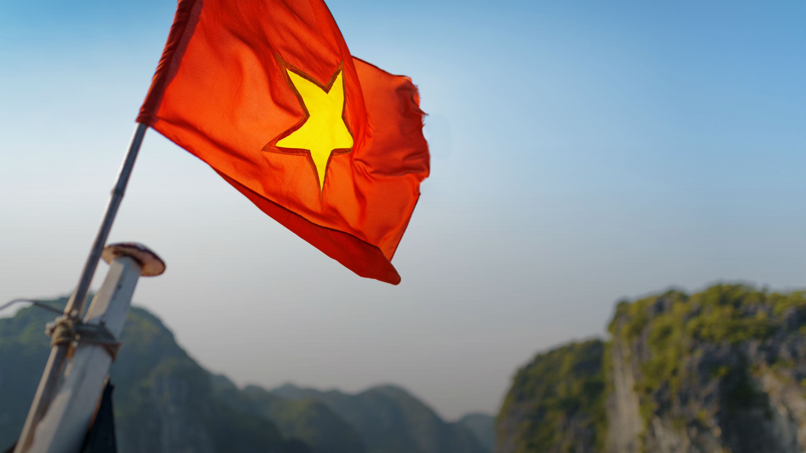 The flag of Vietnam fluttering on ship in the Halong Bay
