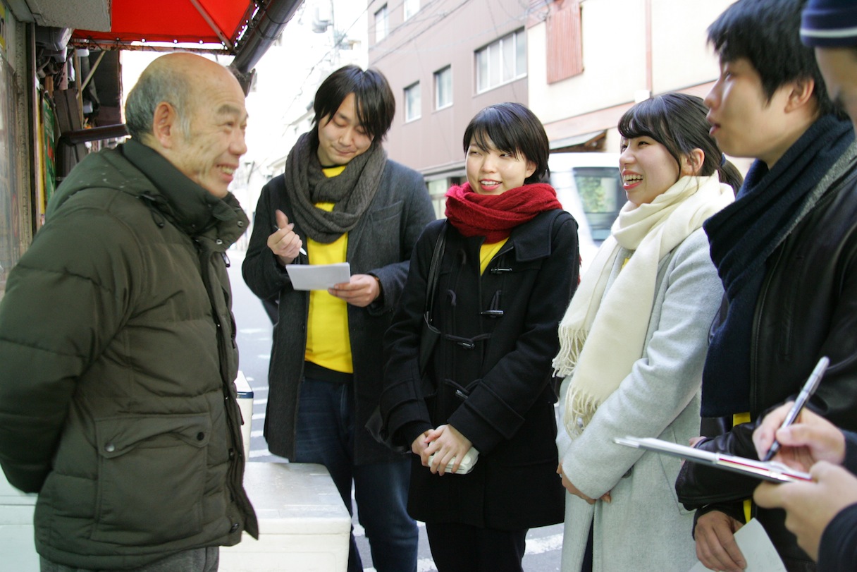 天神橋筋商店街でお店の方にインタビューする参加者たち