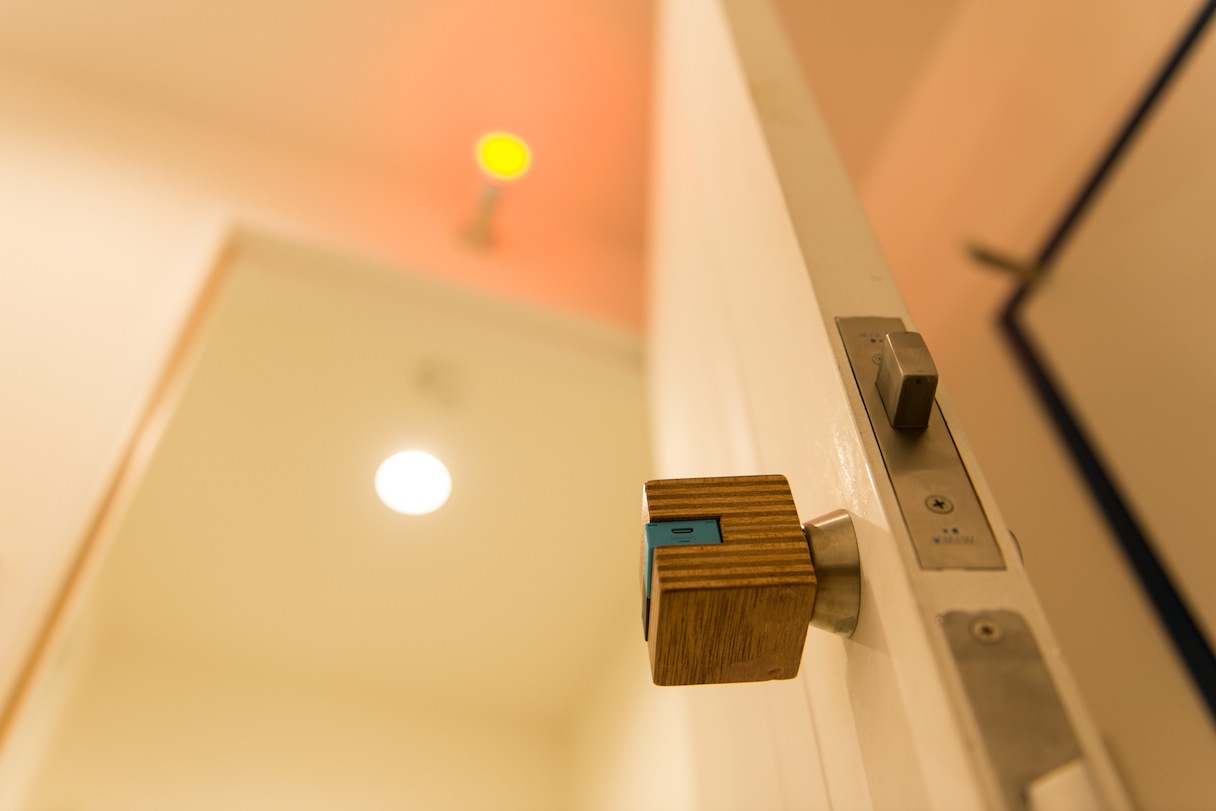 シャワールームの扉の鍵に付けられているのは、ブロック形状をした電子タグのソニー「MESH」。近くに置いたボックスとBluetoothで通信する