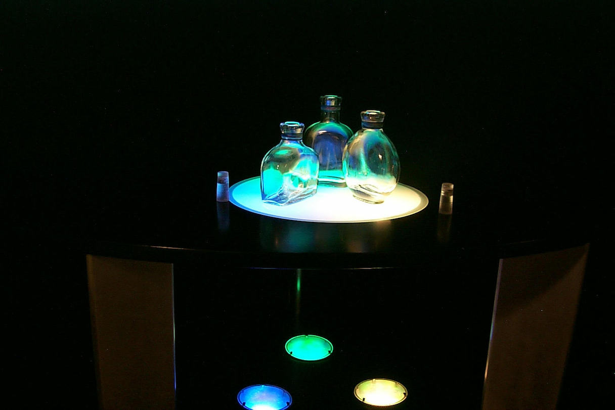 musicBottles（1999）／透明なガラスの小瓶を音声データのストレージ兼コントローラーにしたこの作品は「SIGGRAPH '99」で発表。ユーザーは「蓋の開け閉め」というインタラクションで操作を行い、まるで「ジャズの小瓶」や「天気予報の小瓶（翌日が晴れなら鳥の鳴き声、雨なら雨音が流れる）」の中にあるコンテンツを外に開放する感覚を得る（提供：石井教授）