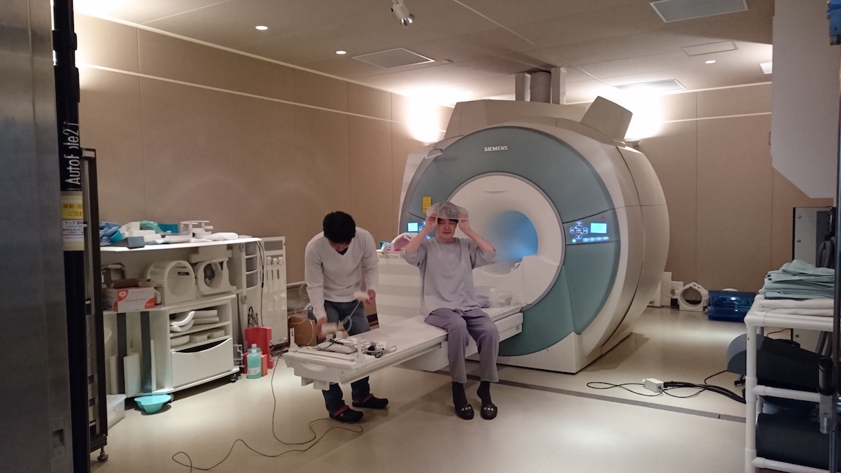 「NeuroAI® D-Planner」の脳活動計測を前に、fMRI（機能的MRI）内での動画視聴に備えて準備する被験者　©NICT・CiNet