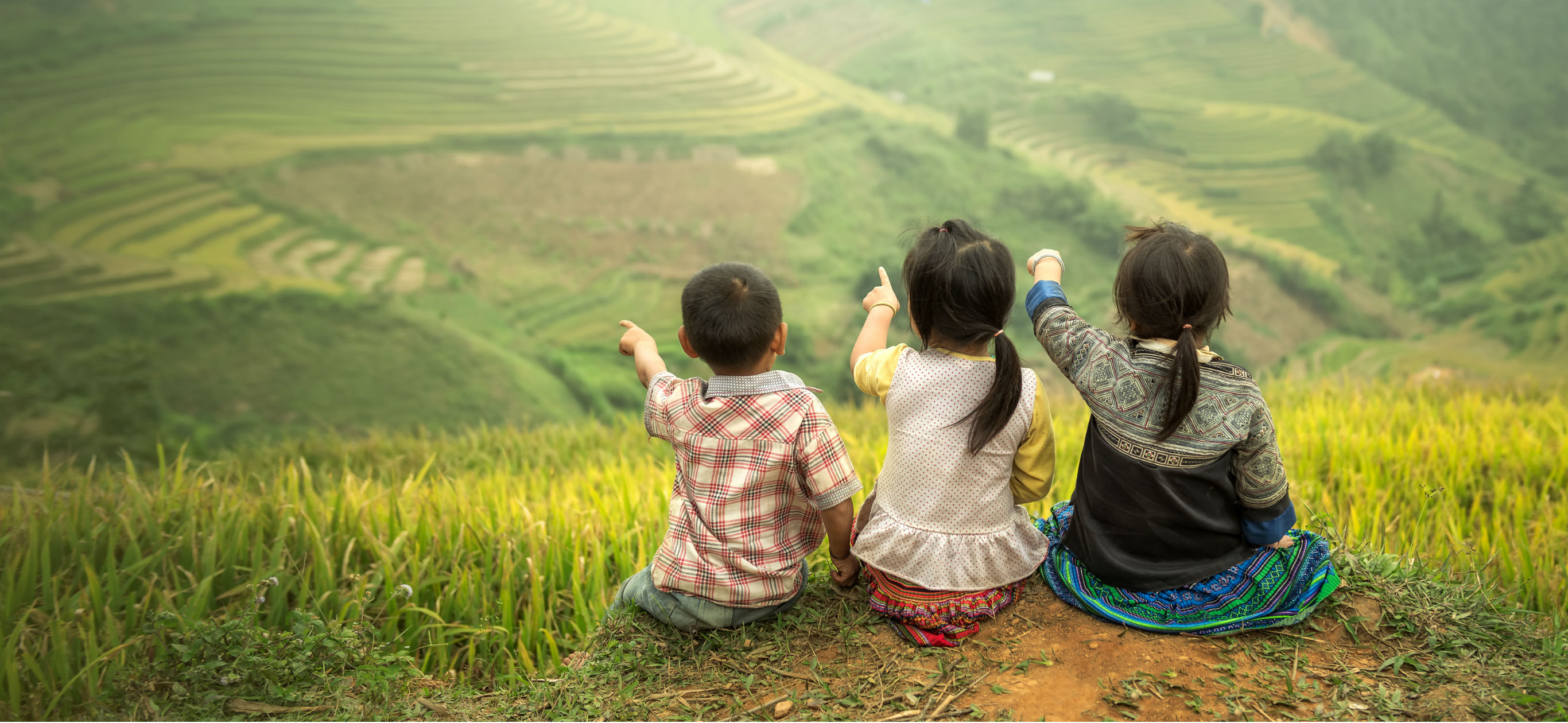 Three children sitting side by side, Mu Cang Chai, YenBai, Vietnam.