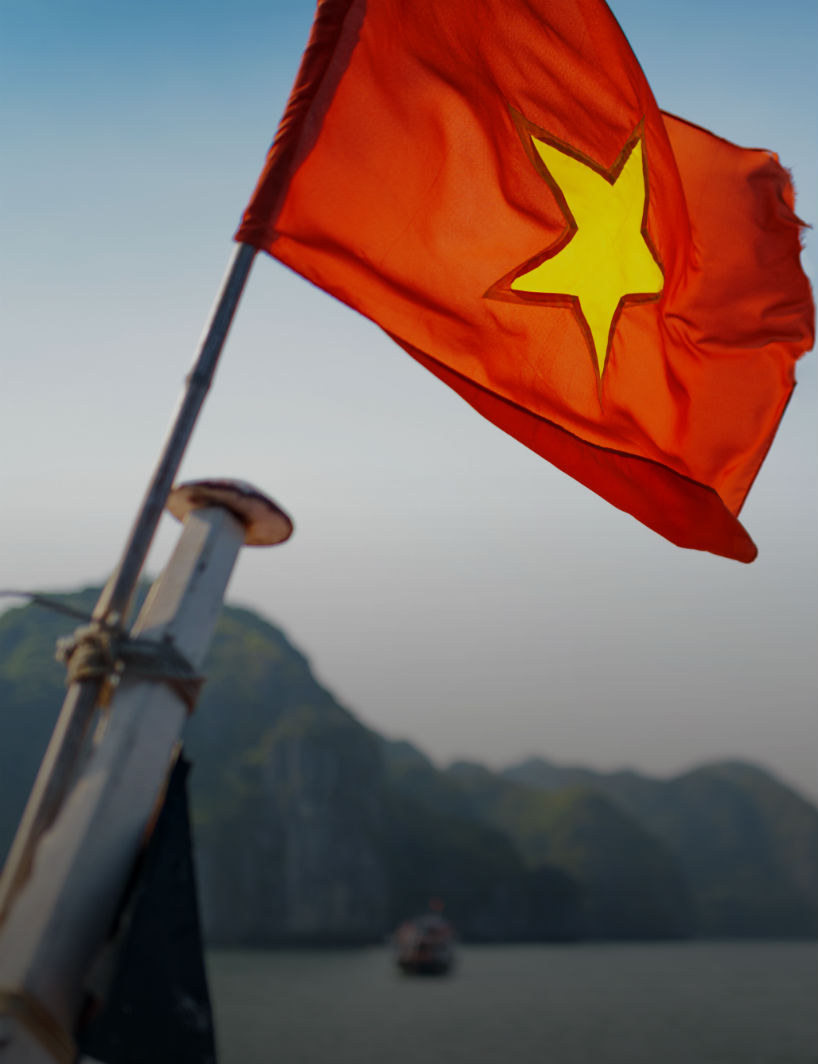 The flag of Vietnam fluttering on ship in the Halong Bay